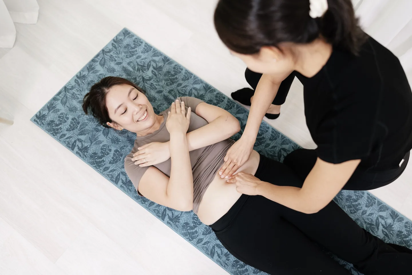 A Goji physiotherapist guiding a mother through a postpartum recovery assessment.