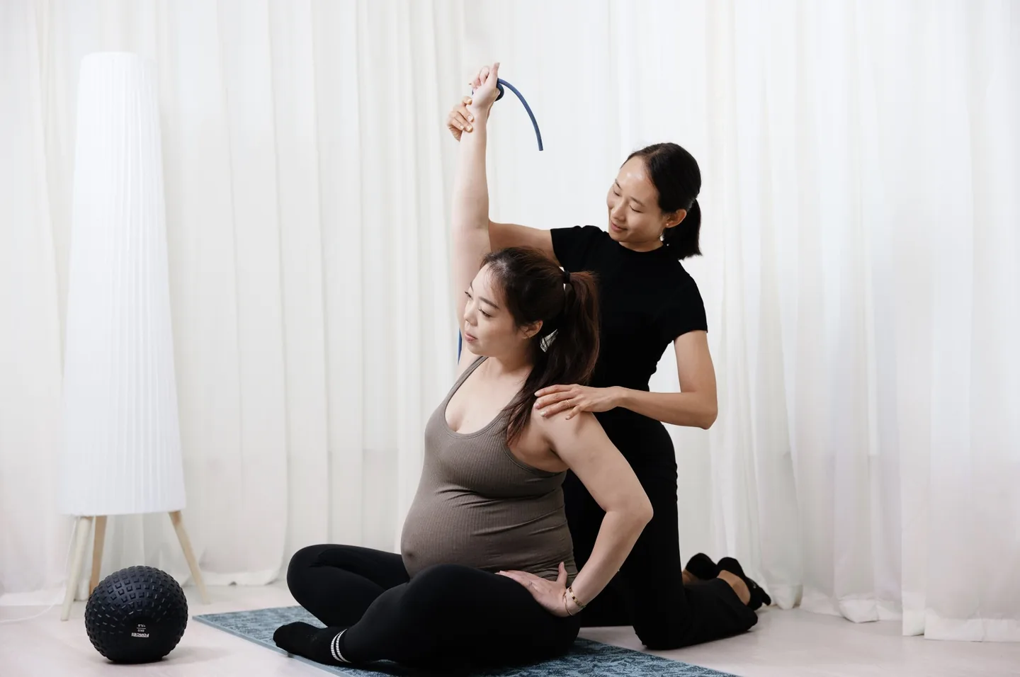 A pregnant woman working with a Goji physiotherapist during a prenatal assessment.