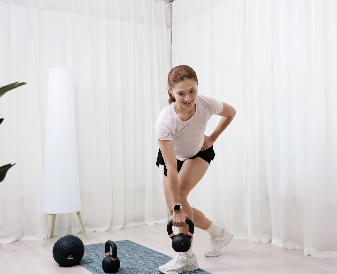A woman training with a kettlebell during a Goji Strength & Conditioning session.